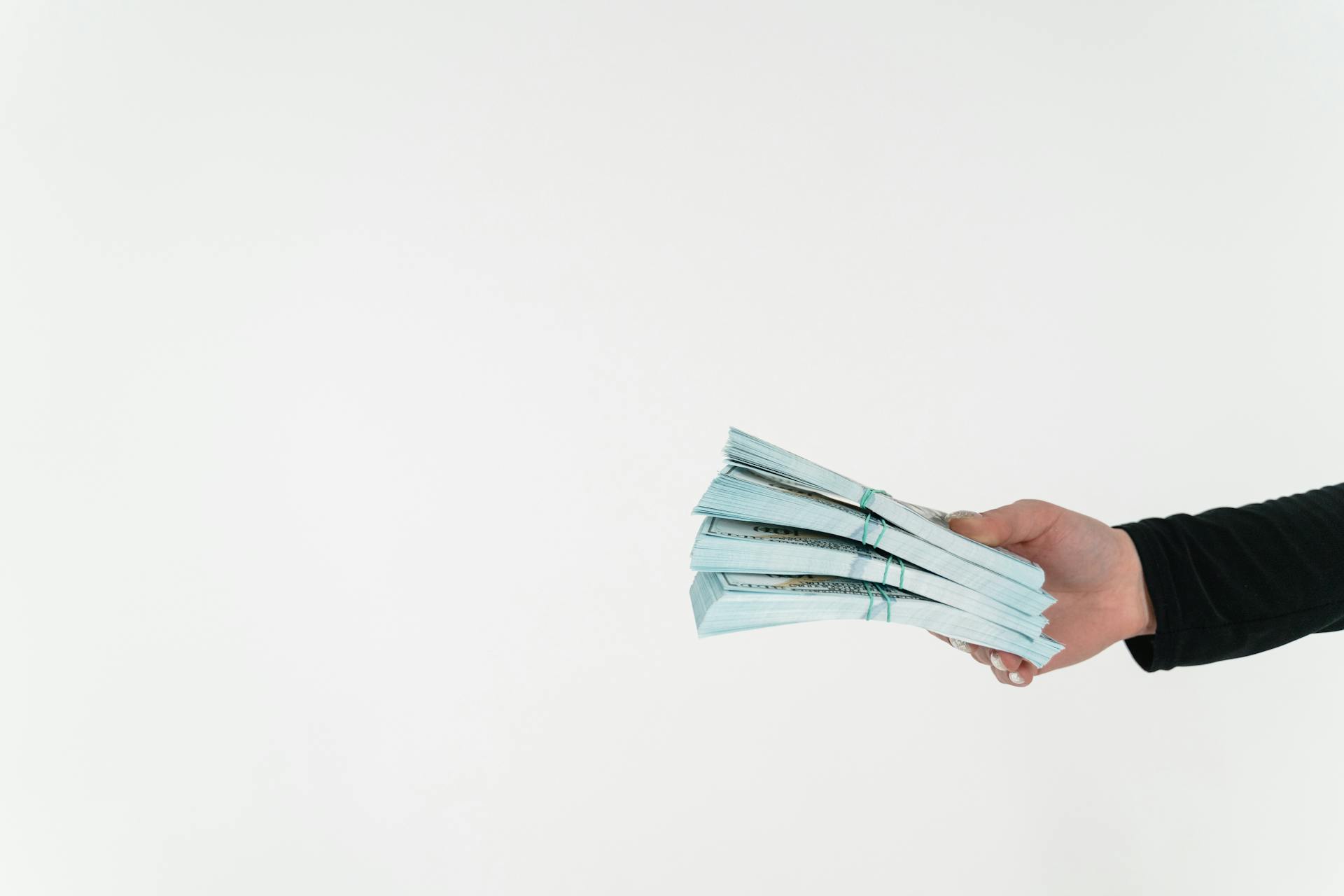 Woman holding bundles of cash | Source: Pexels