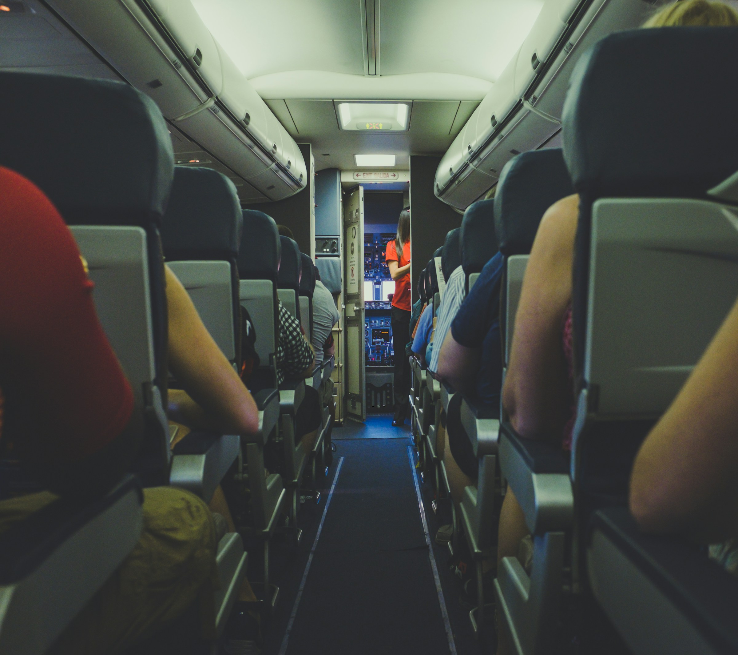 A flight attendant and passengers in the front part of the plane | Source: Unsplash