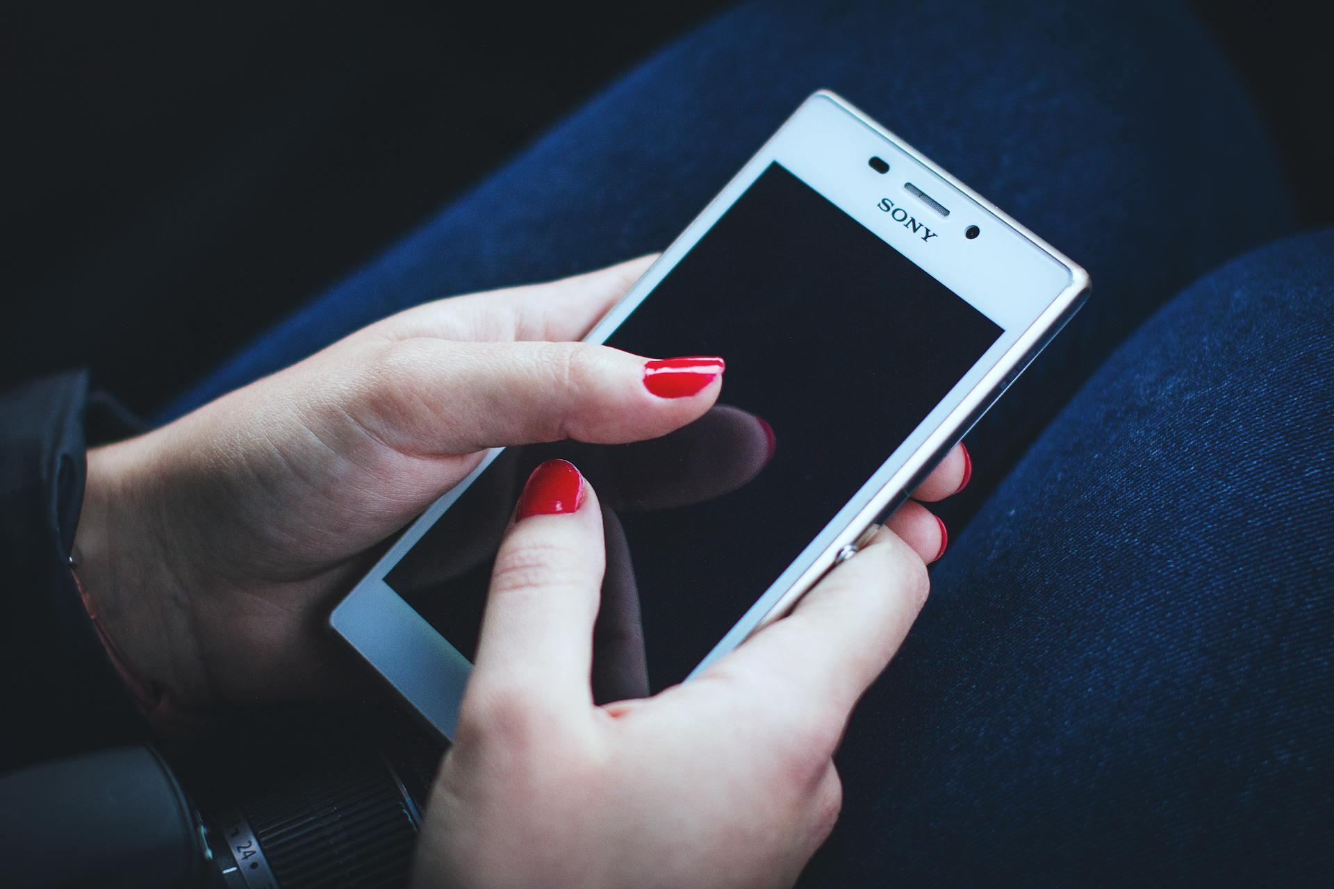 A woman holding her phone | Source: Pexels