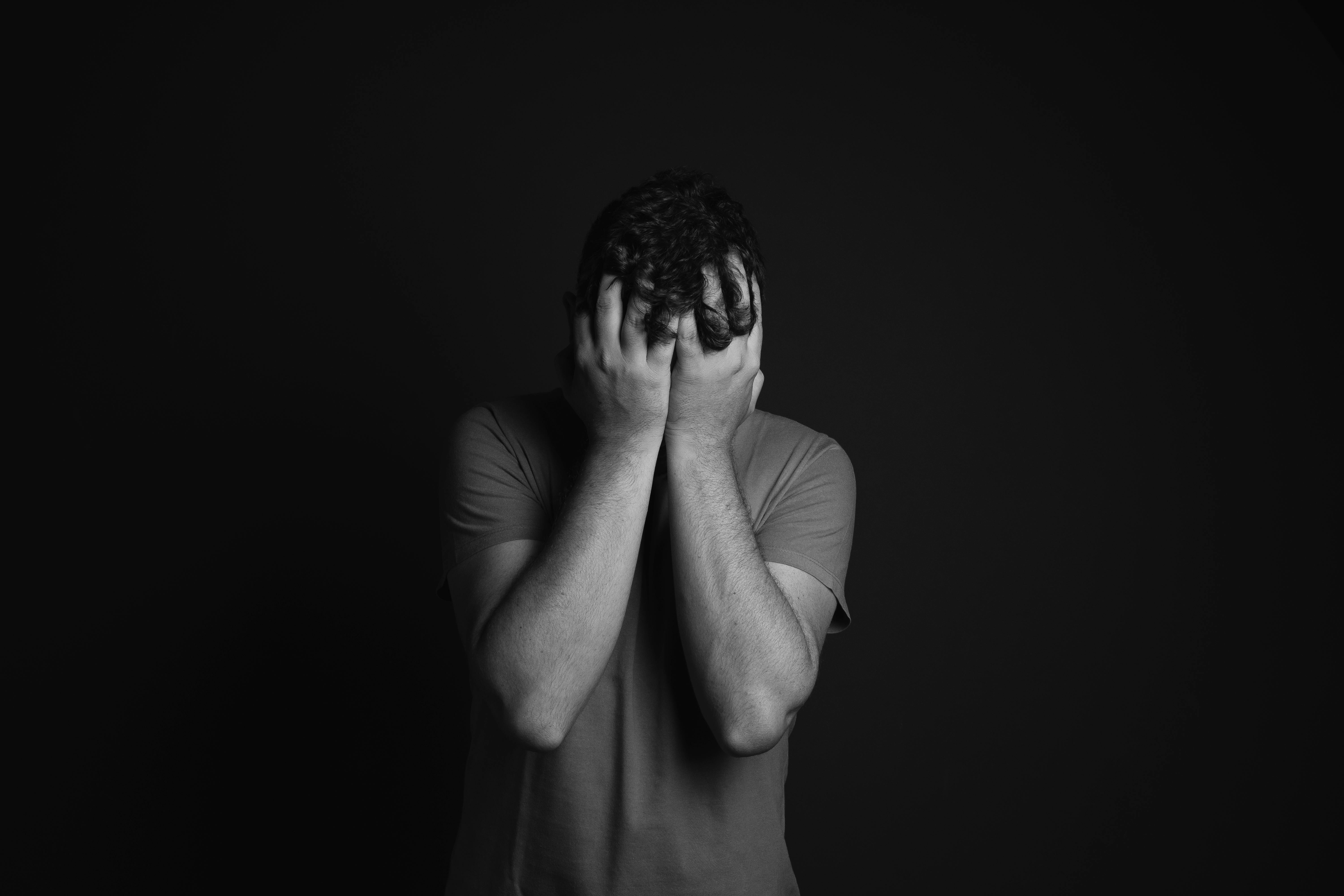 A sad man covering his face with his palms | Source: Pexels