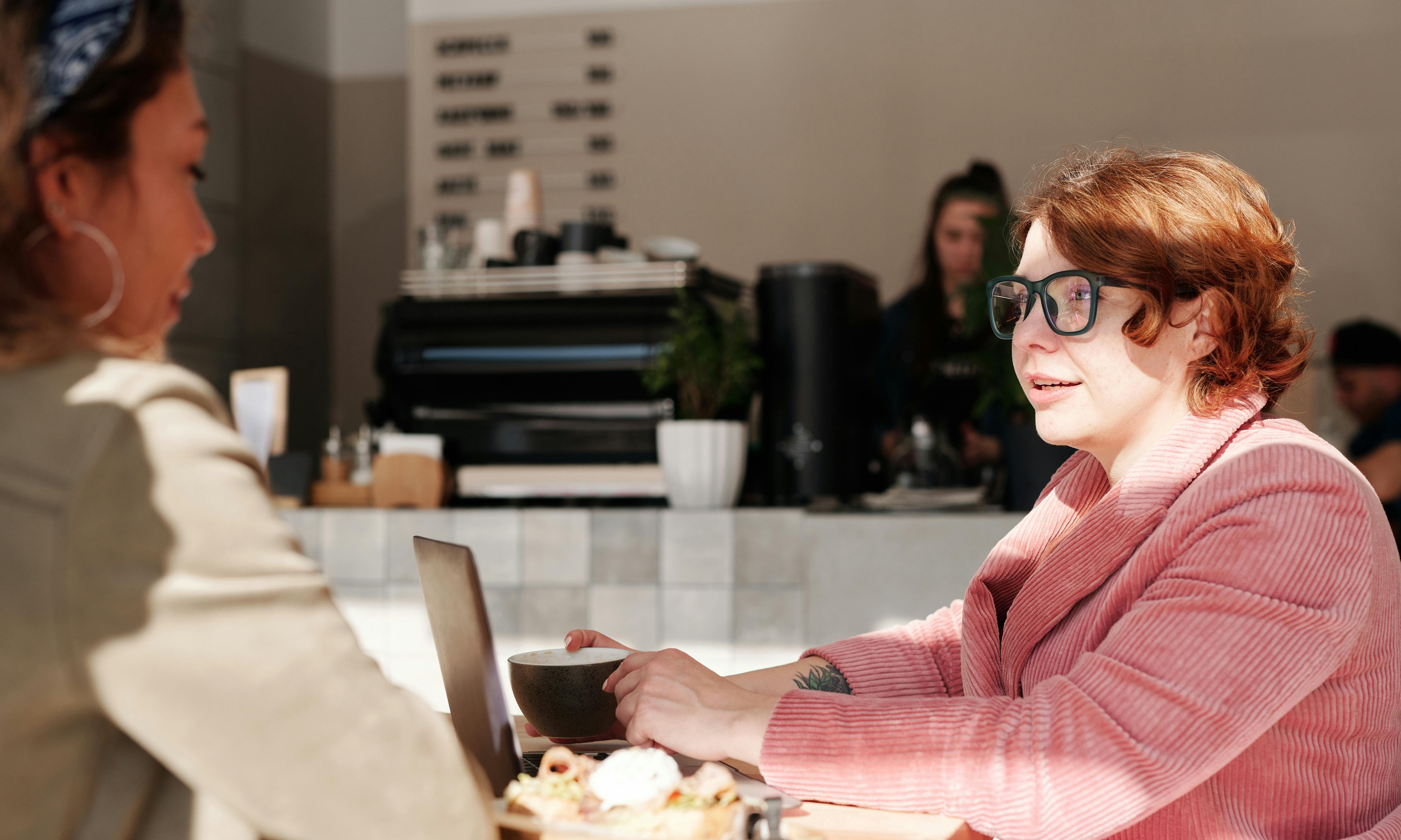 Elly sharing her triumph with her friend Sarah over coffee | Source: Pexels