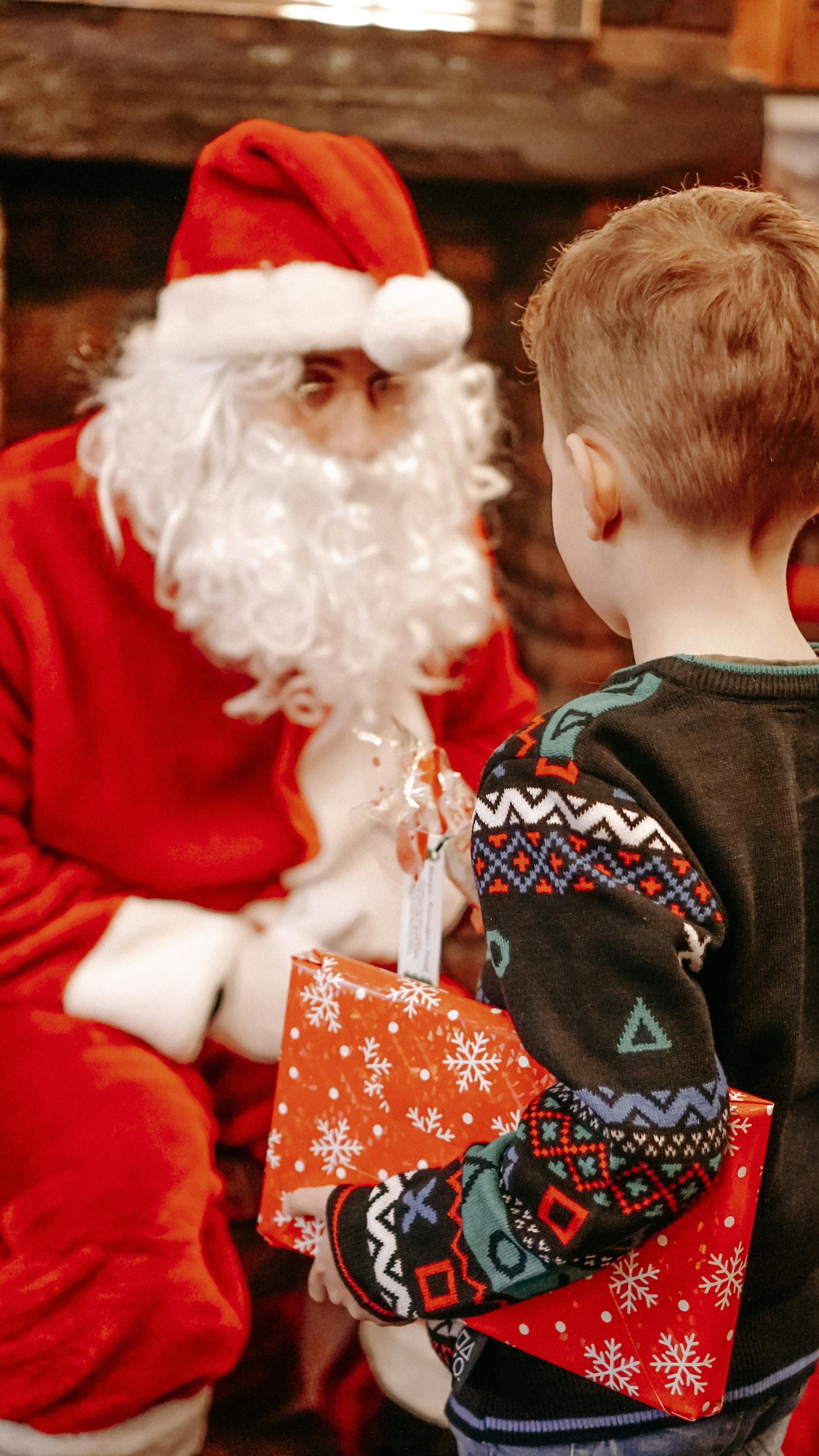 A little boy receives a present from Santa Claus on Christmas | Source: Pexels