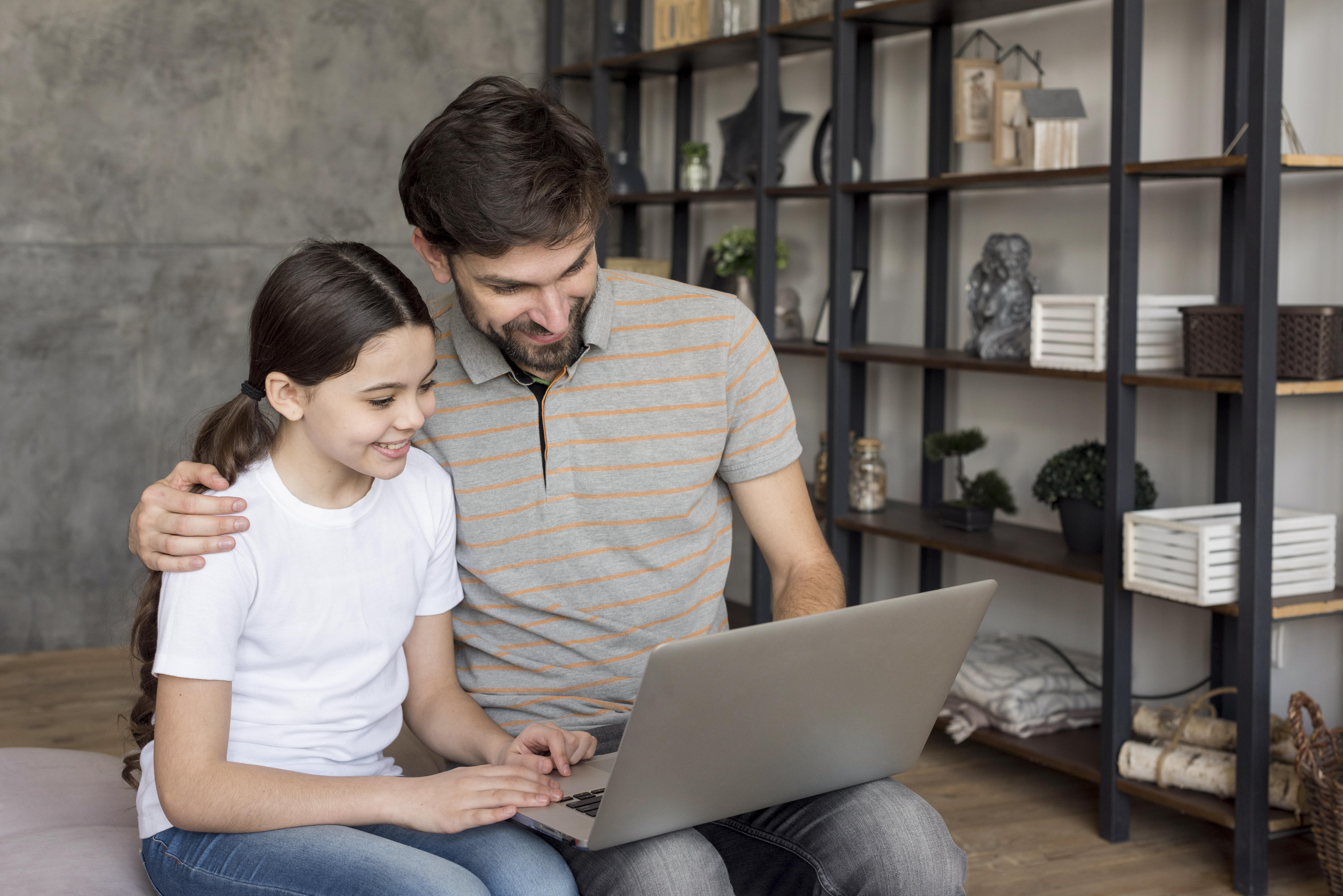 A girl and her dad using a laptop | Source: Freepik