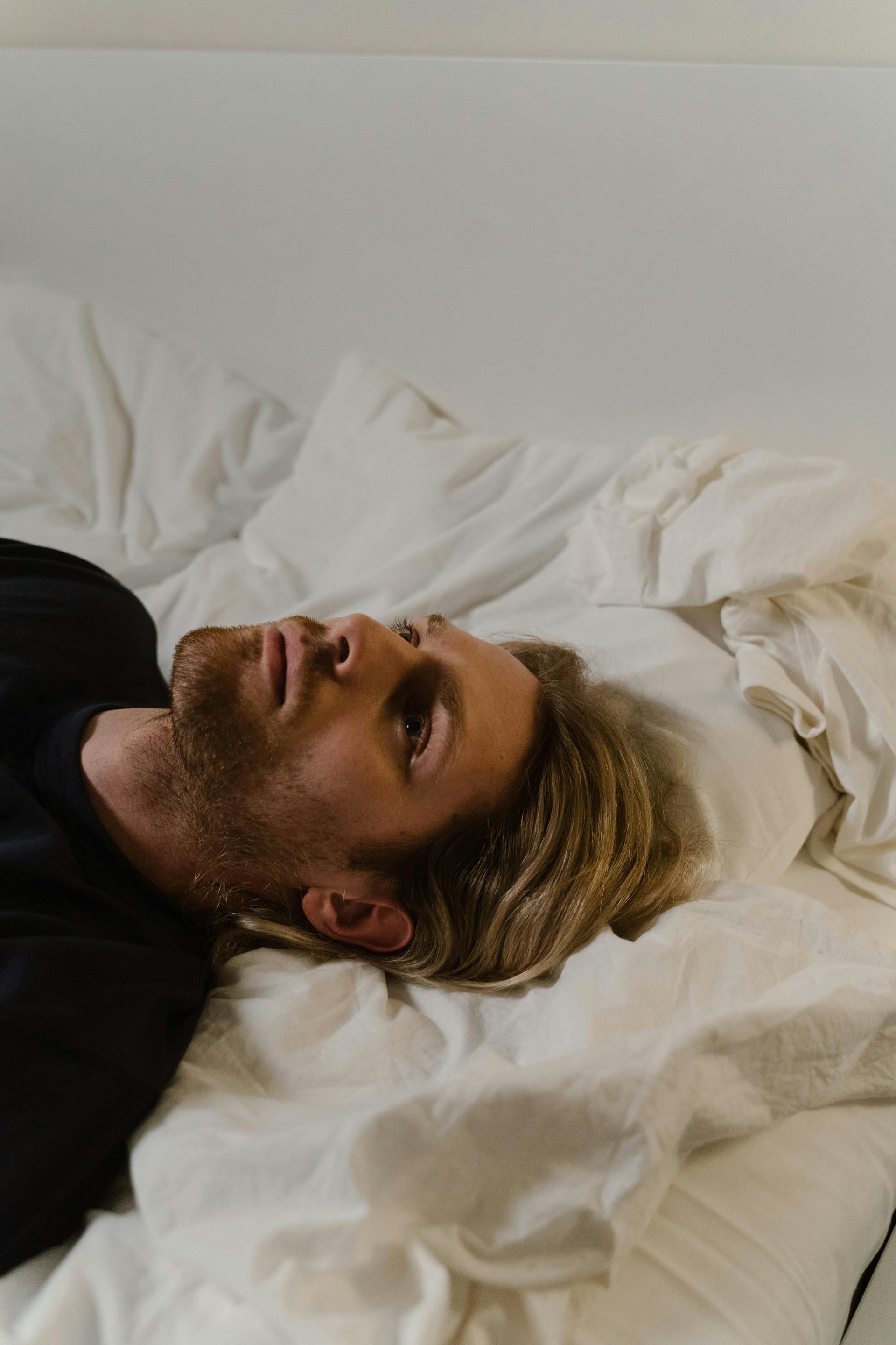 A man lying on the bed with his eyes open | Source: Pexels